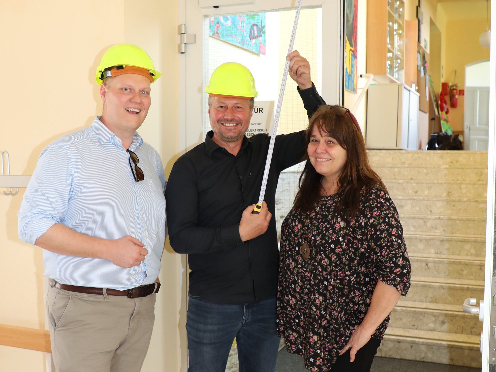 Bildungsstadtrat Martin Zöhrer und Bürgermeister Peter Molnar, ausgerüstet mit Bauhelmen und Maßband, gemeinsam mit Direktorin Marianne Stromberger in der Volksschule Egelsee