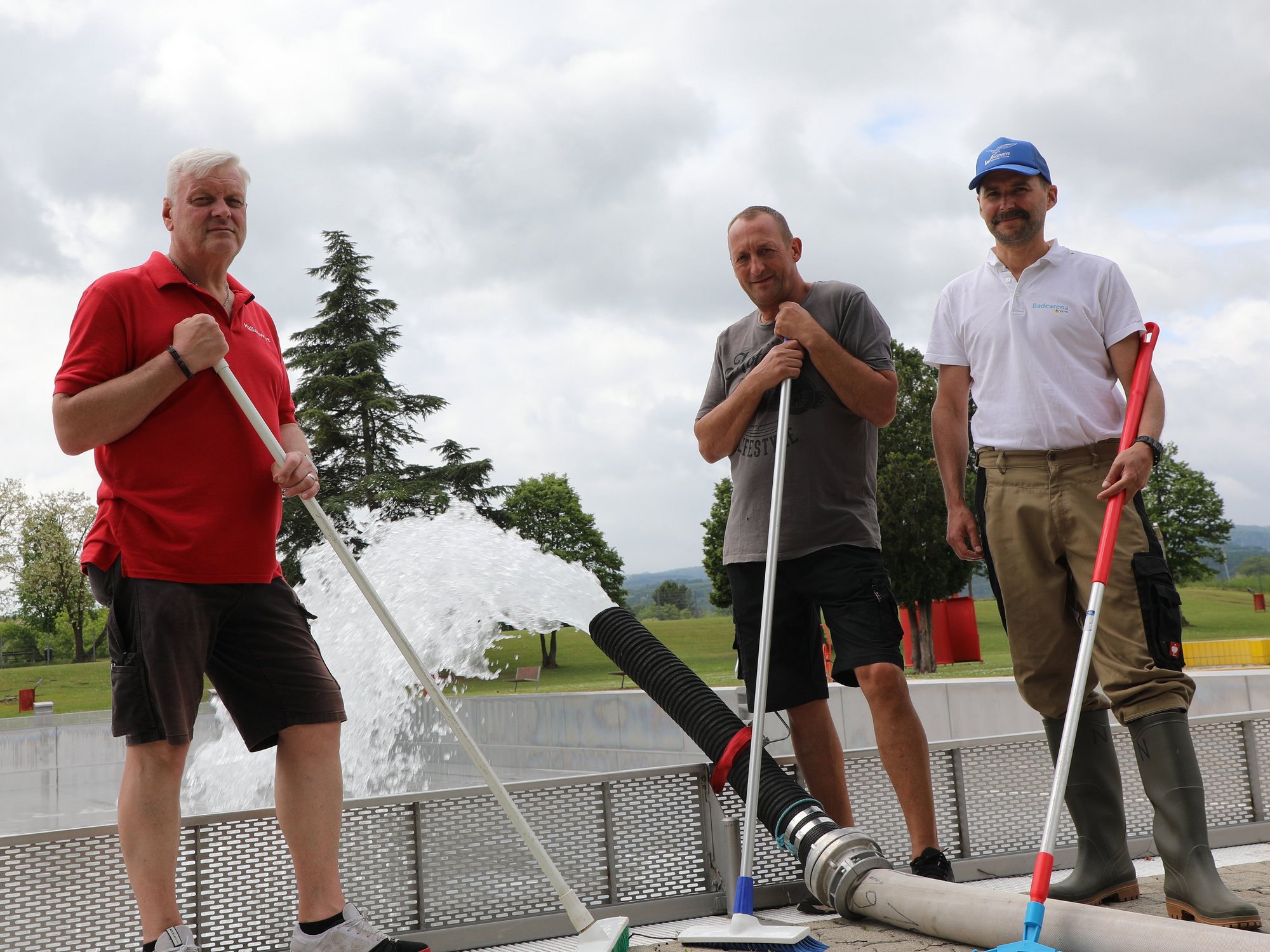 Drei Mitarbeiter der Sport- und Freizeitbetriebe bereiten das Freibad auf die neue Saison vor