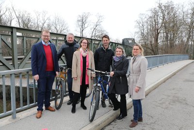 Sechs Vertreter:innen aus Politik und Verwaltung vor der Eisenbahnbrücke