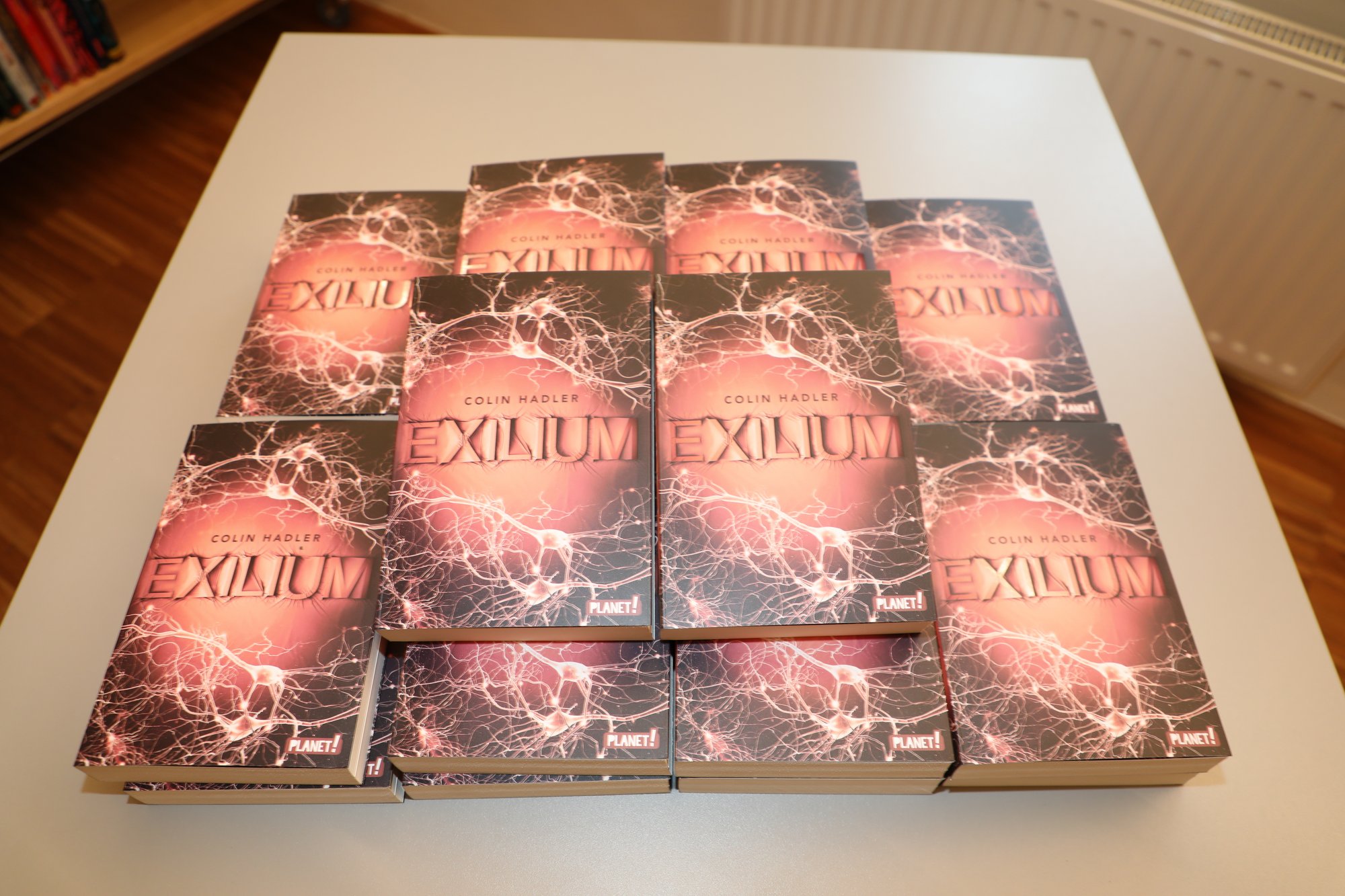 Büchertisch mit dem Roman "Exilium" von Colin Hadler