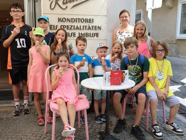 Gruppe Kinder mit Eistüten an einem Cafe-Tisch