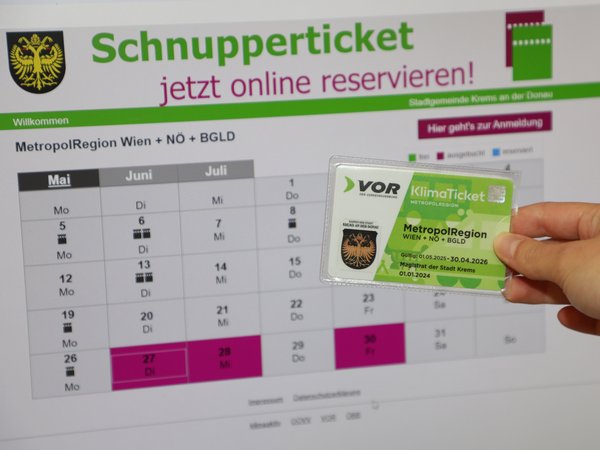 Das Bild zeigt eine Online-Reservierungsseite für das Schnupperticket der Stadt Krems für das KlimaTicket MetropolRegion. Zusätzlich wird eine Hand gezeigt, die ein KlimaTicket hä