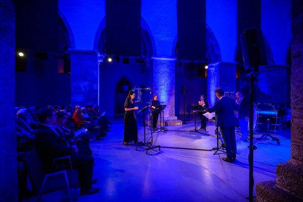 Foto einer Sängergruppe in der Minoritenkirche getaucht in blaues Licht