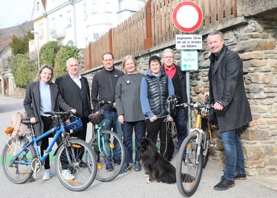 Personengruppe vor dem Schild des neuen Radwegs