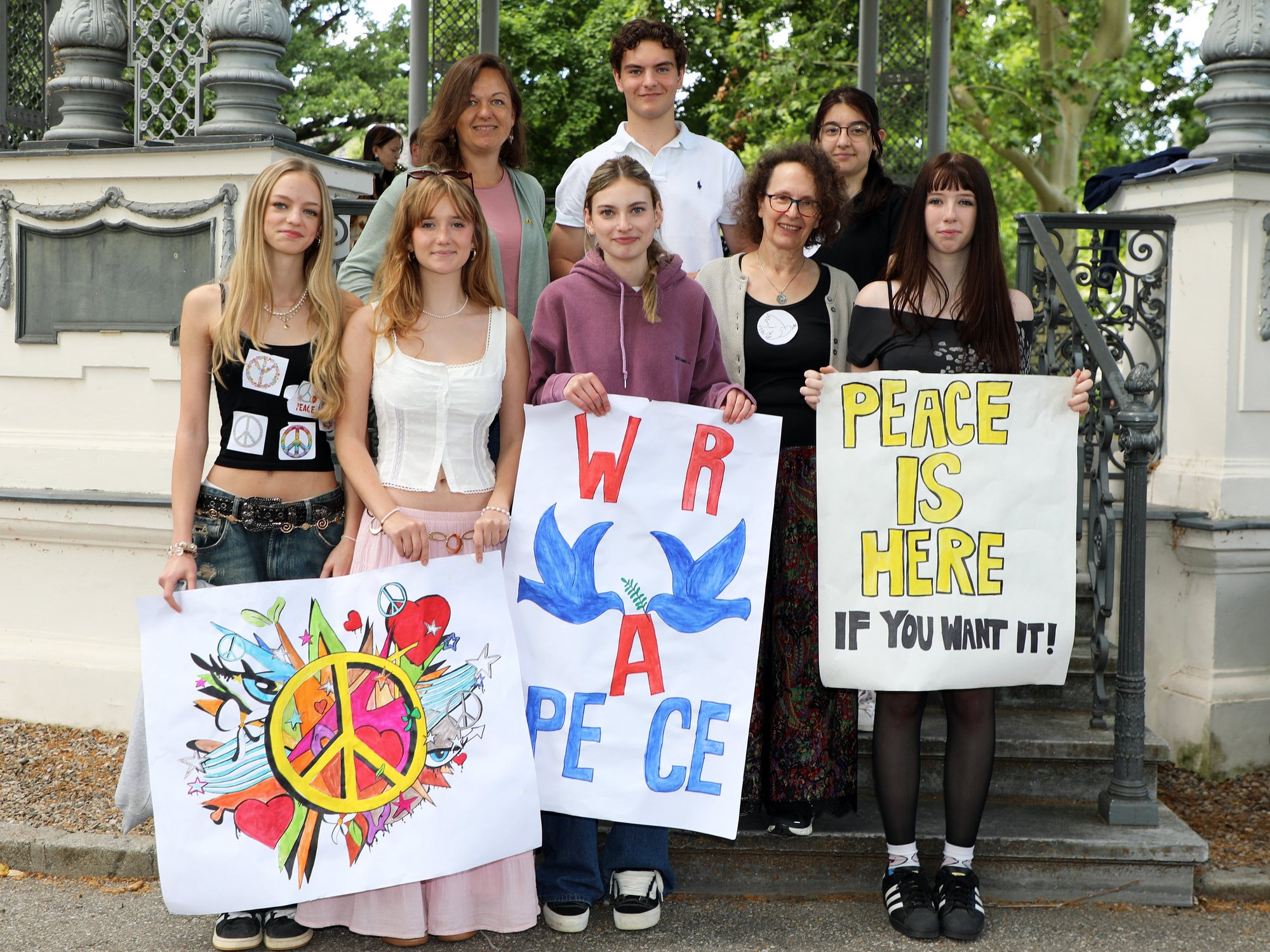 Gruppe mit Friedenstransparenten vor dem Pavillon im Kremser Stadtpark