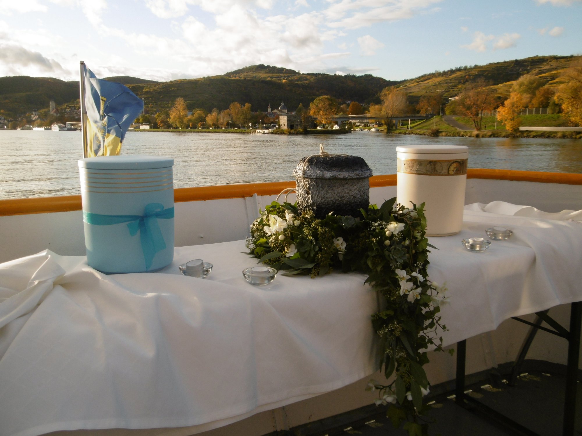 Urne auf einen Schiff, dahinter die Donau