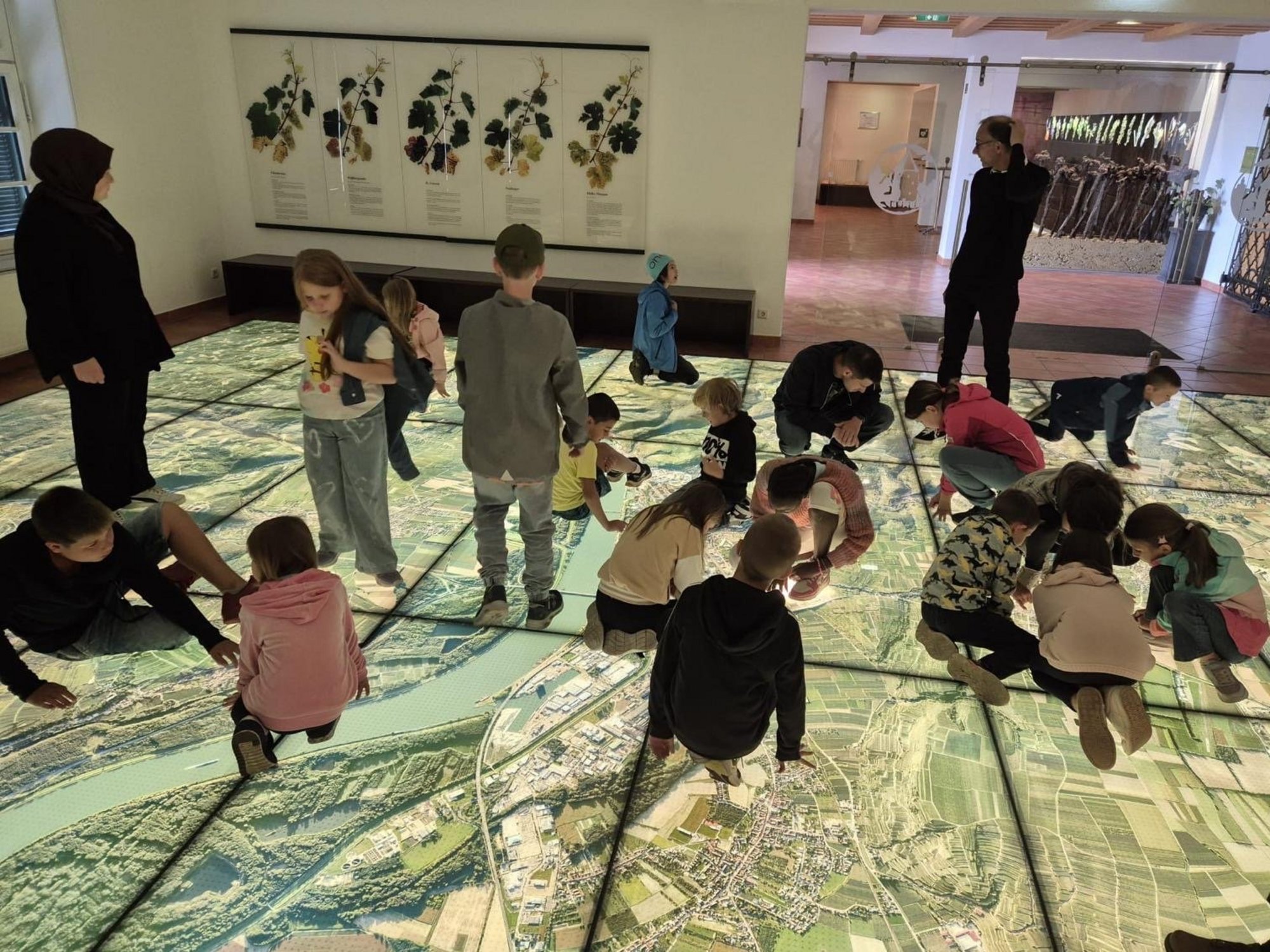 Kindergruppe erkundet eine begehbare Luftbildkarte.