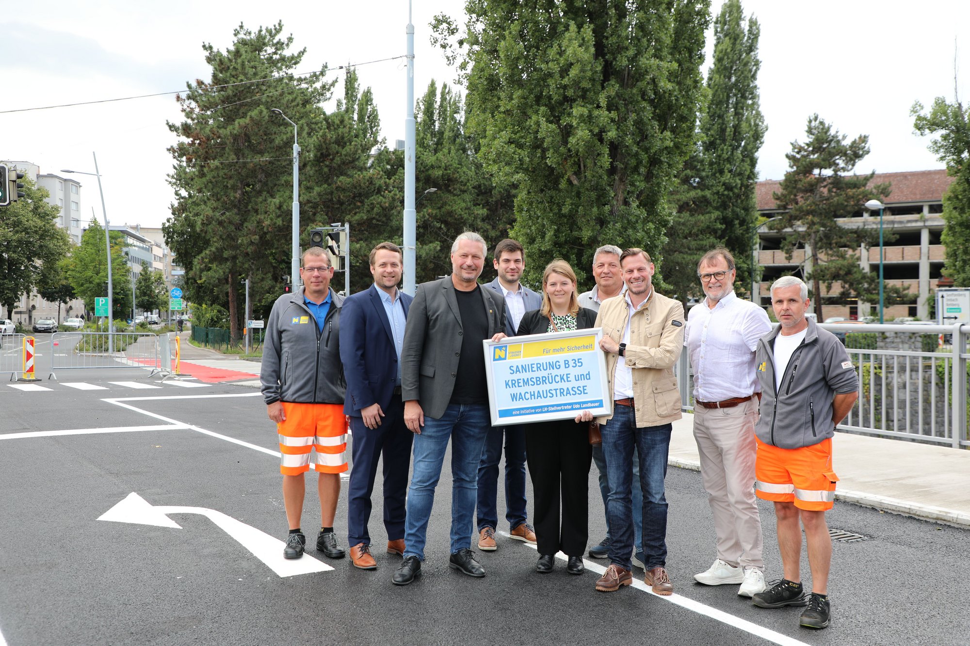 Männer und Frauen auf der Kremsbrücke bei der Fertigstellung der Sanierungsarbeiten