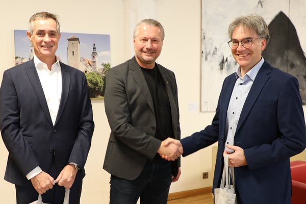 Kremser Bank Vorstandsdirektorn im Bürgermeisterbüro mit Bürgermeister, der mit Handshake gratuliert