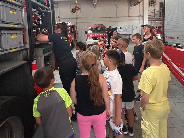 Kindergruppe bei einer Feuerwehrführung in der Fahrzeughalle der Feuerwehr Krems.