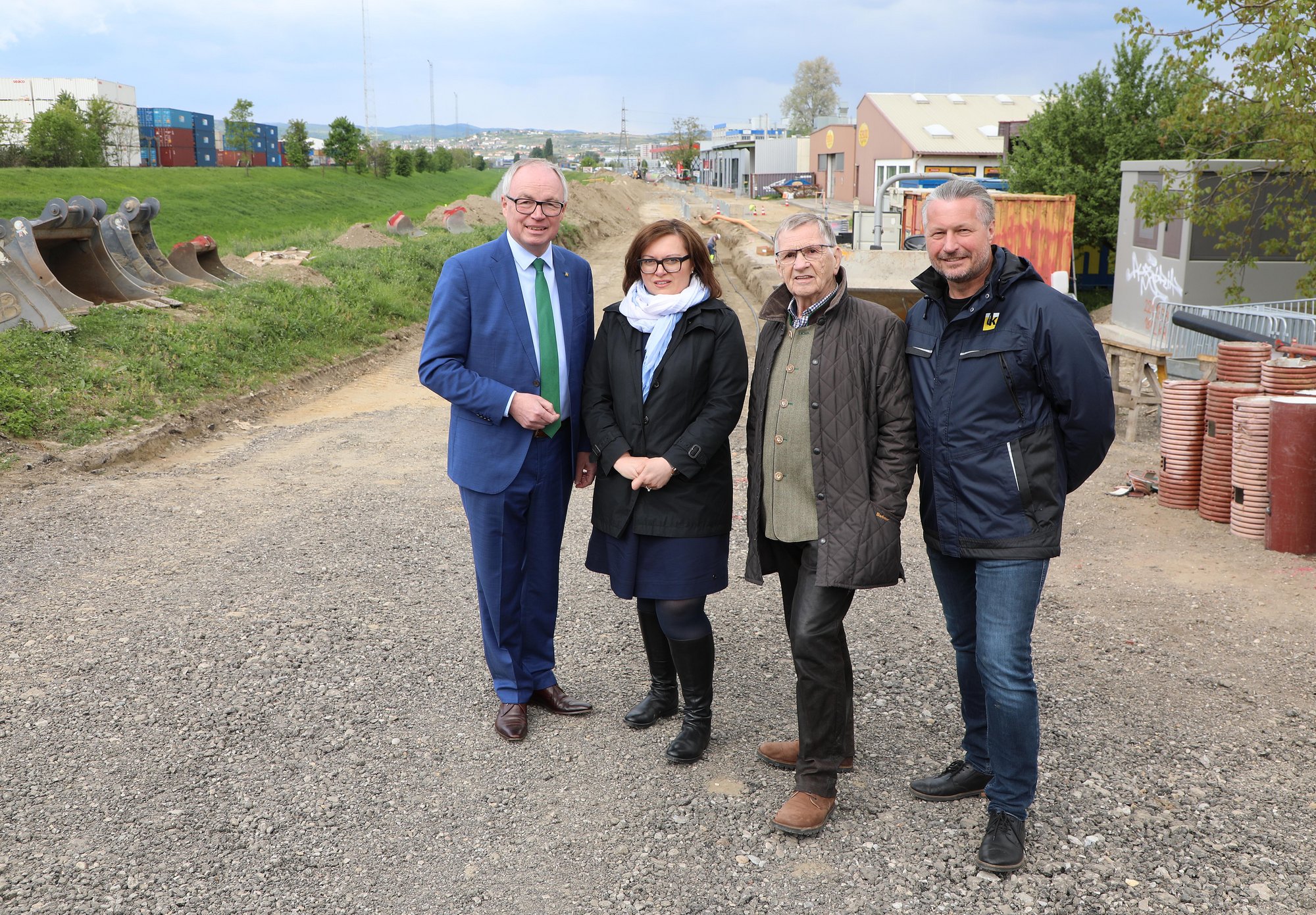 Vier Vertreter von Stadt, Land und Bund vor der Baustelle im Kremser Gewerbegebiet