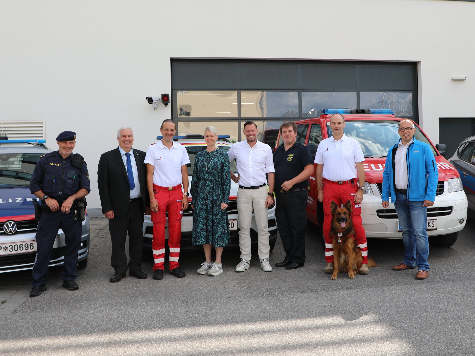 Gruppenfoto von Einsatzkräften und Vertreter:innen vor Einsatzfahrzeugen in Krems.