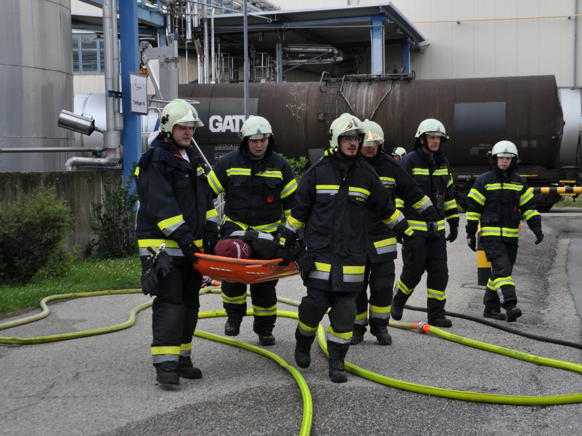 Eine Gruppe Feuerwehrleute trägt einen "Verletzten" (Puppe) davon.