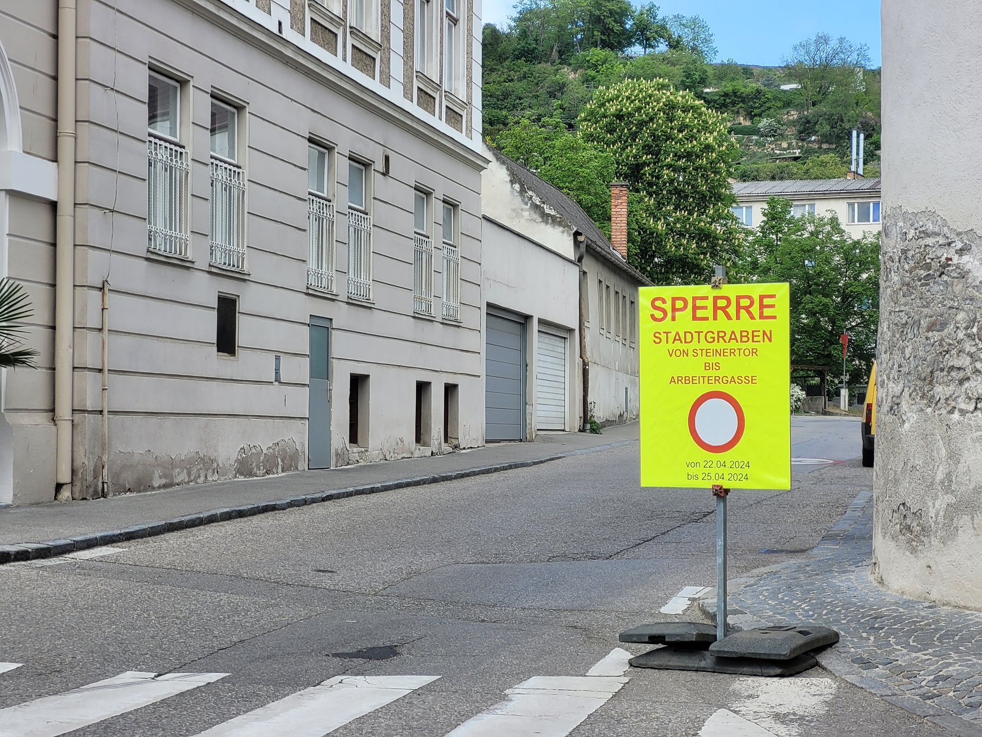 Blick in den Stadtgraben, im Vordergrund ein Baustellenschild, das auf die bevorstehende Sperre hinweist