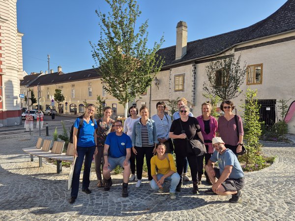 Gruppe von Personen auf einem Platz in der Altstadt von Krems bei sonnigem Wetter.