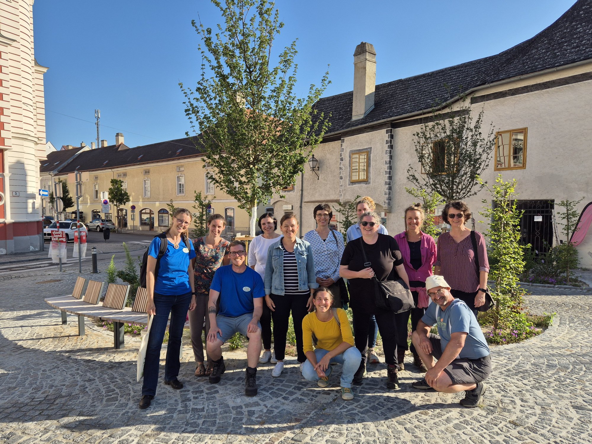 Gruppe von Personen auf einem Platz in der Altstadt von Krems bei sonnigem Wetter.