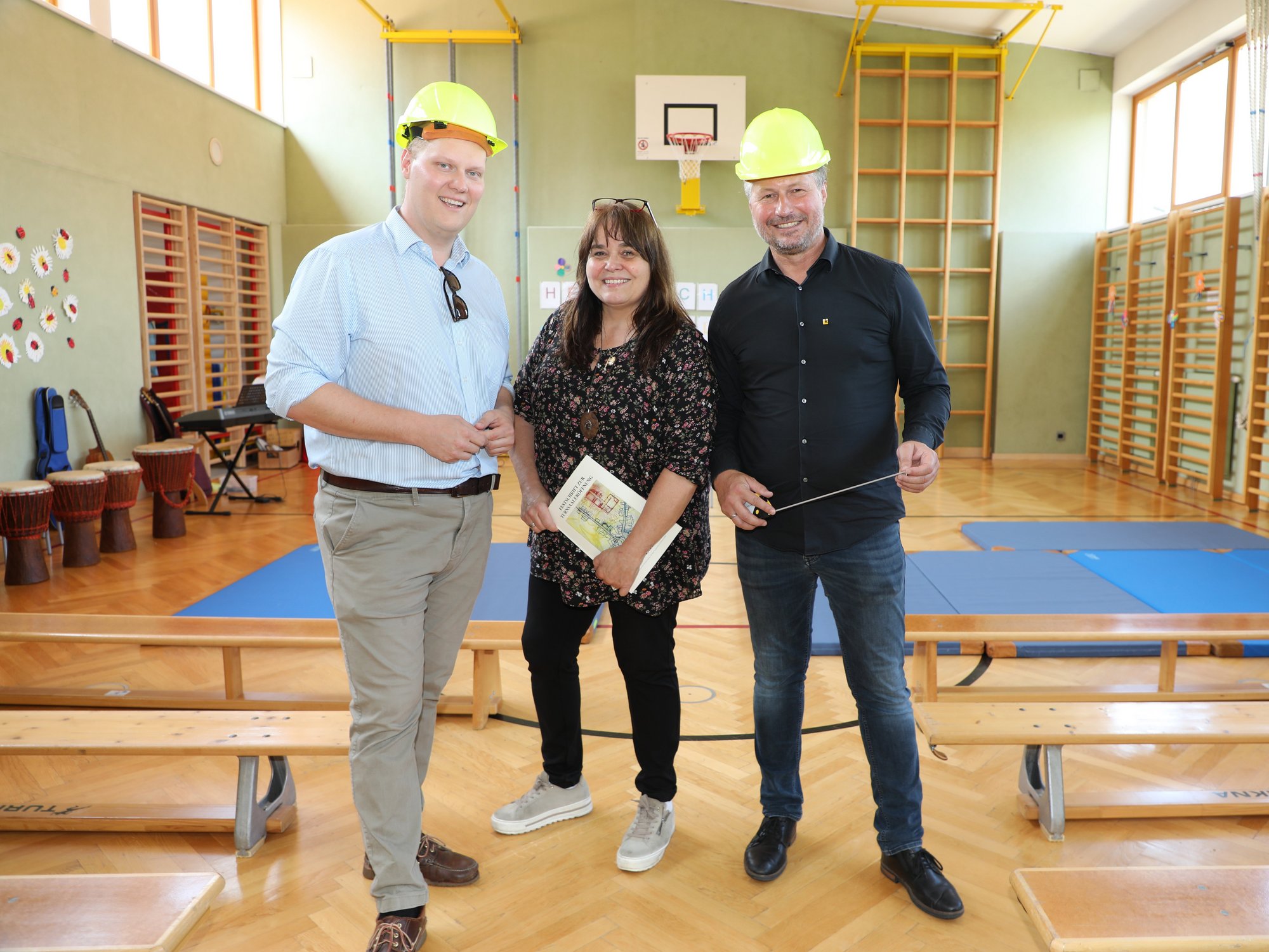 Bildungsstadtrat Martin Zöhrer und Bürgermeister Peter Molnar, ausgerüstet mit Bauhelmen und Maßband, gemeinsam mit Direktorin Marianne Stromberger in der Volksschule Egelsee