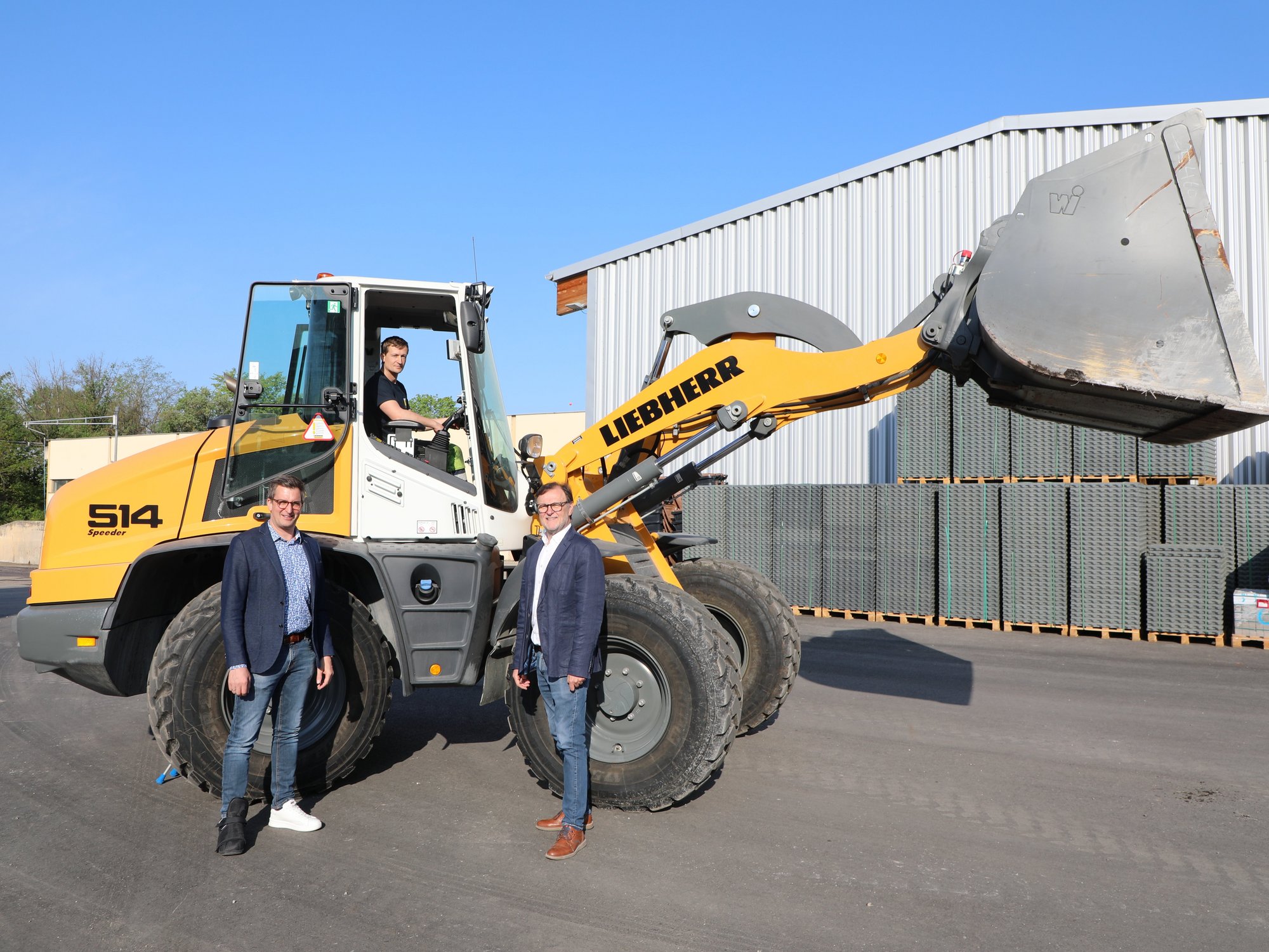 Drei Vertreter der Stadt mit dem neuen Radlader
