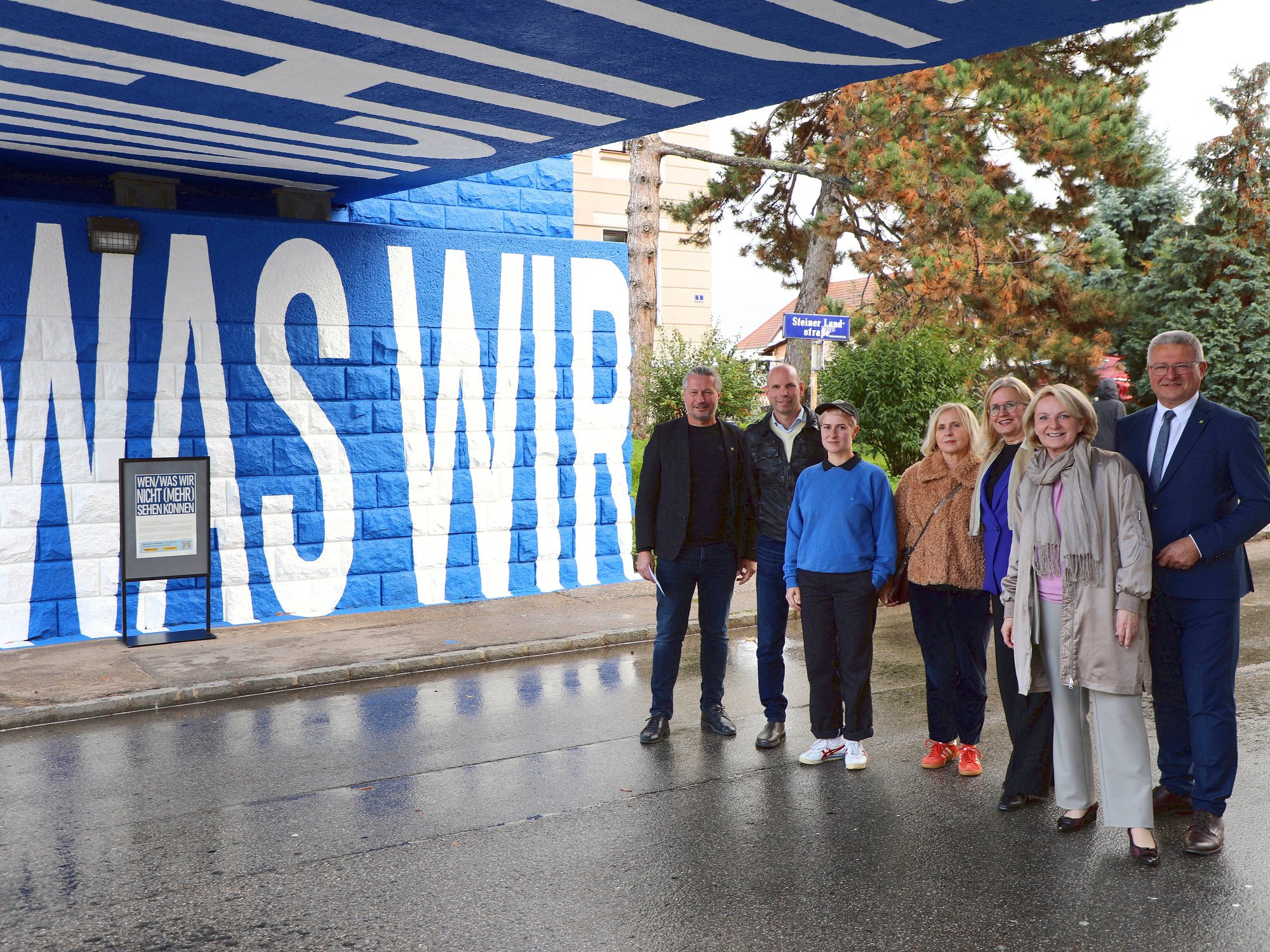 Eröffnungsgäste unter Eisenbahnbrücke beim neuen Kunstwerk