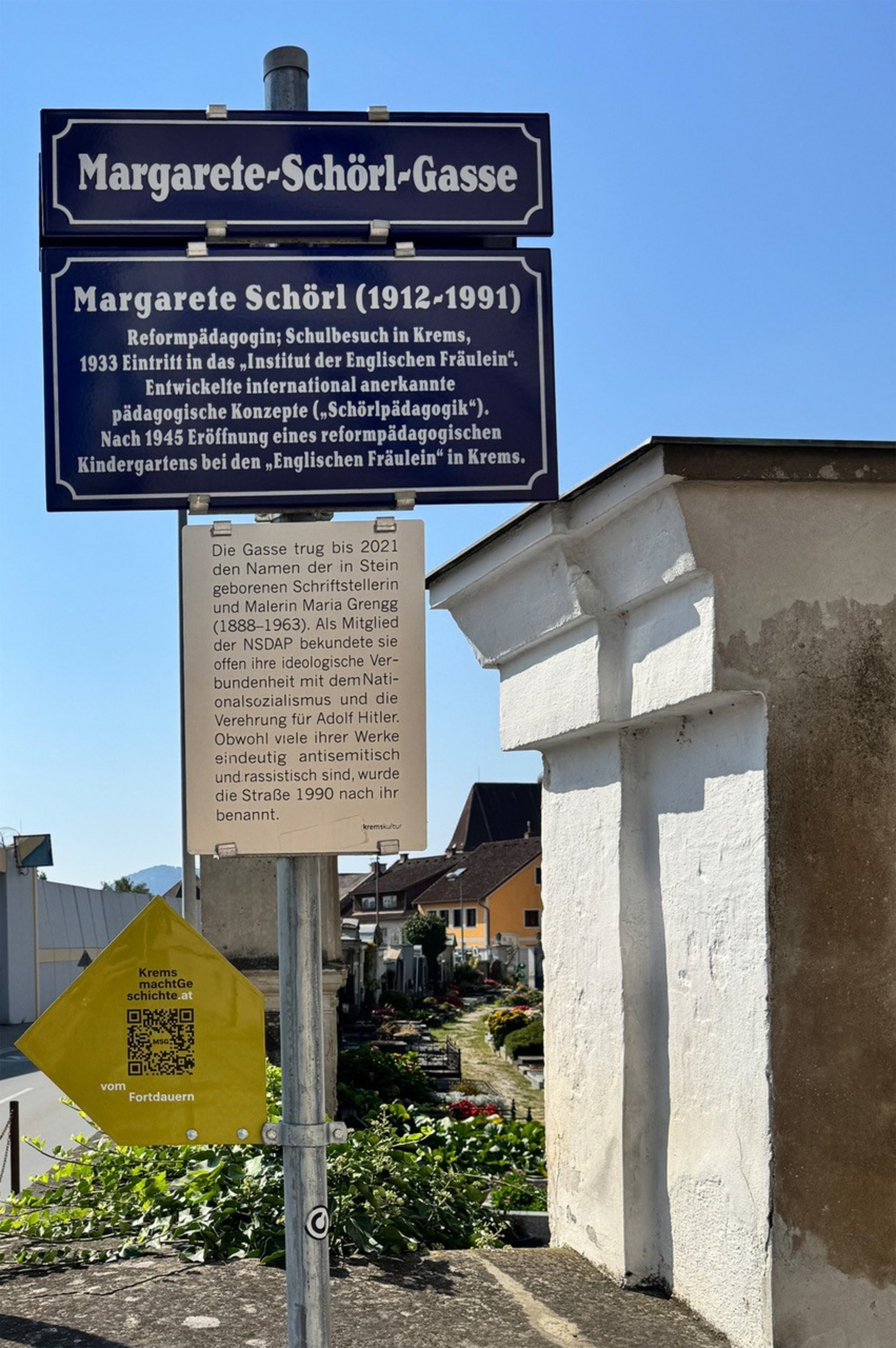 Straßenschild mit erläuternder Zusatztafel der Margarete-Schörl-Gasse 