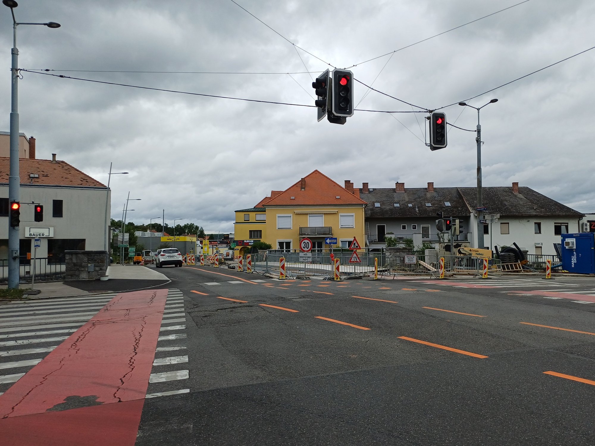 Blick auf die Wachaukreuzung in Krems mit Baustelle und roten Ampeln, im Hintergrund Wohnhäuser und Baustellenabsperrungen.
