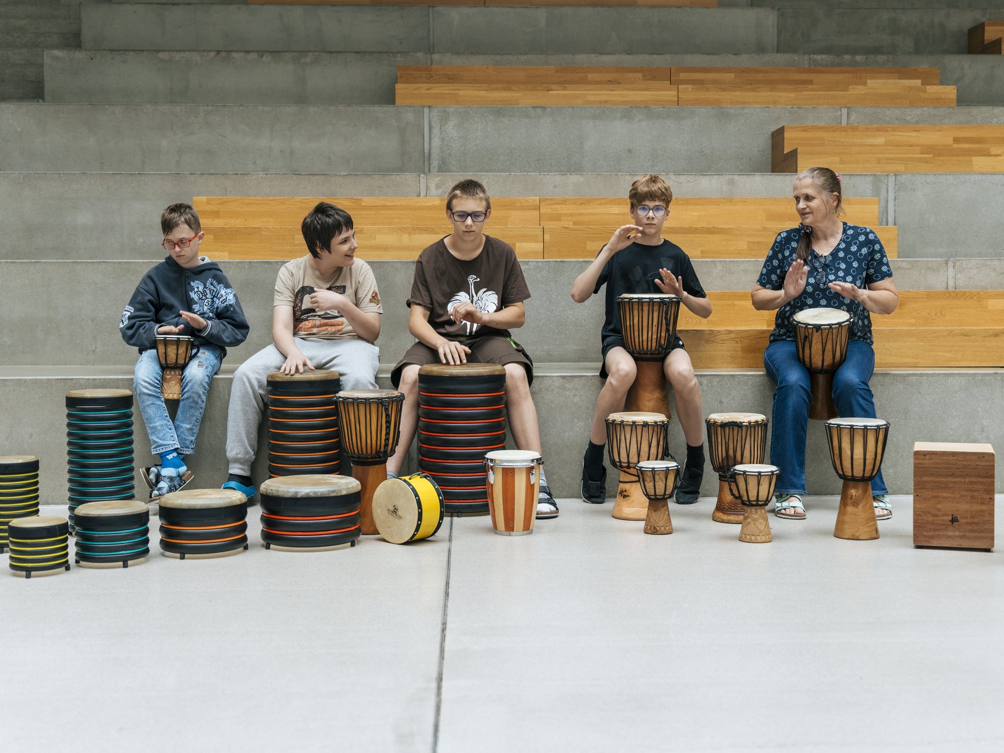 Vier Schüler und eine Lehrerin beim Trommeln 