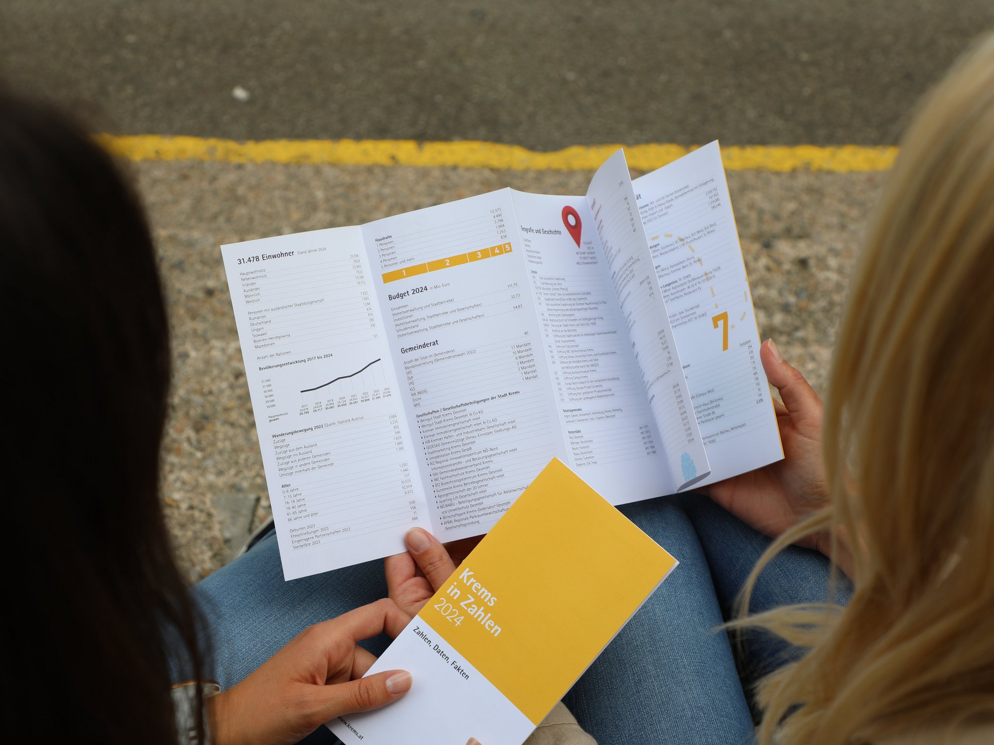 Zwei Frauen blättern durch den neuen Folder