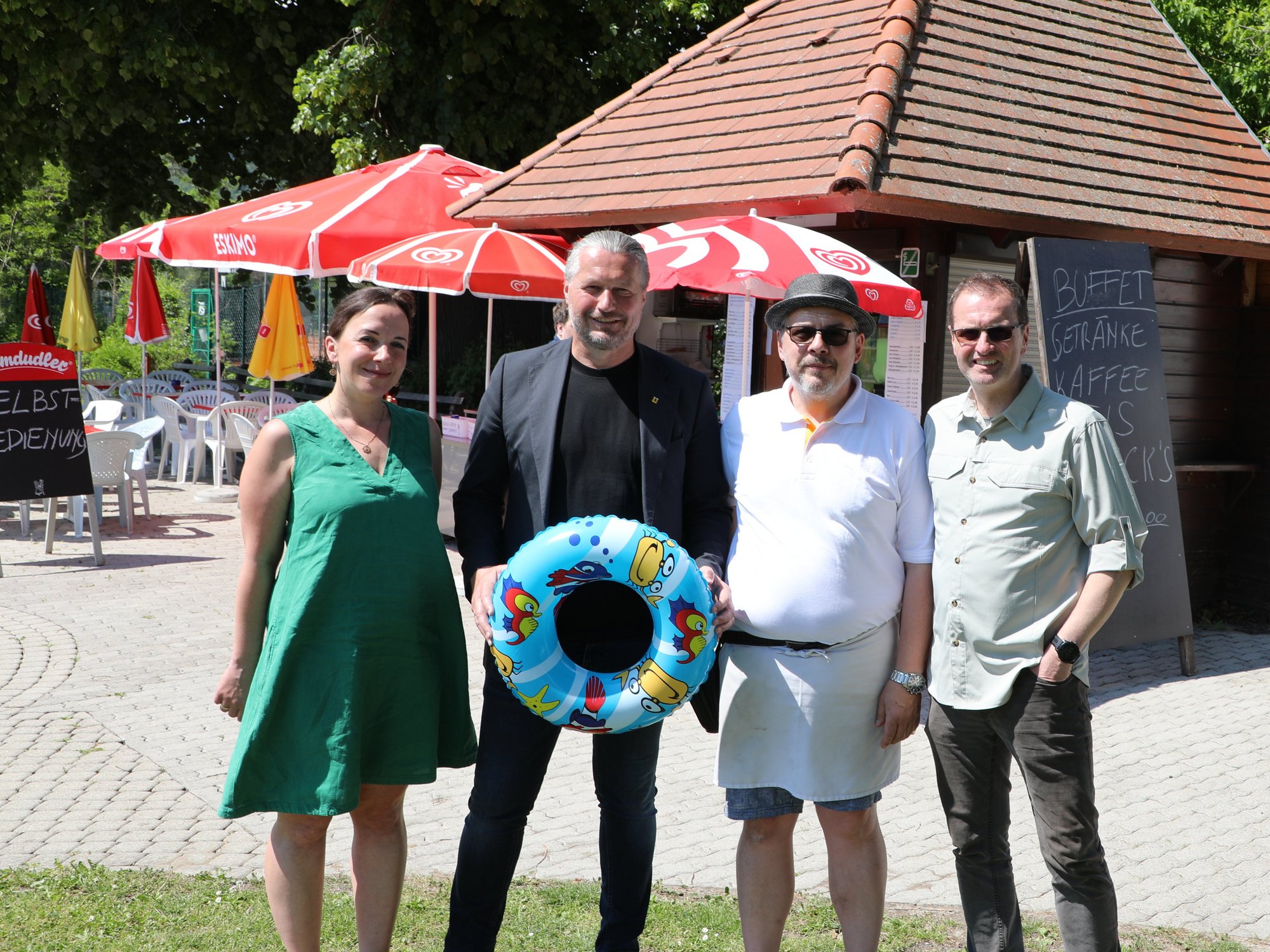 Vier Personen vor dem Kiosk im Kremser Freibad